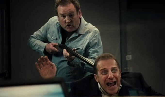 Colm Meaney pointing a shotgun at a radio presenter's head
