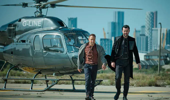 Code 404 - the two leads pictured in front of a helicopter