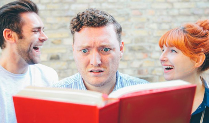 The three podcasters posing in front of a book