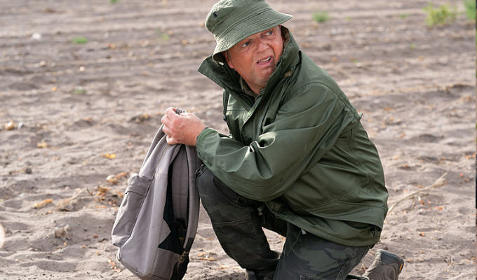 Toby Jones as Lance looking furtive as he discovers something in a field