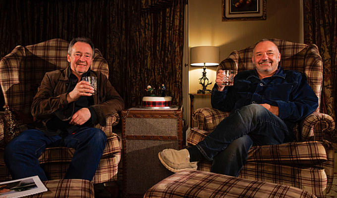 Paul and Bob sitting in comfy armchairs with a dram of whisky