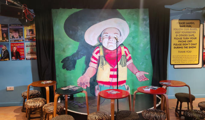 New backdrop, a painting of child as a cowboy with his hands in front of him, palms outwards