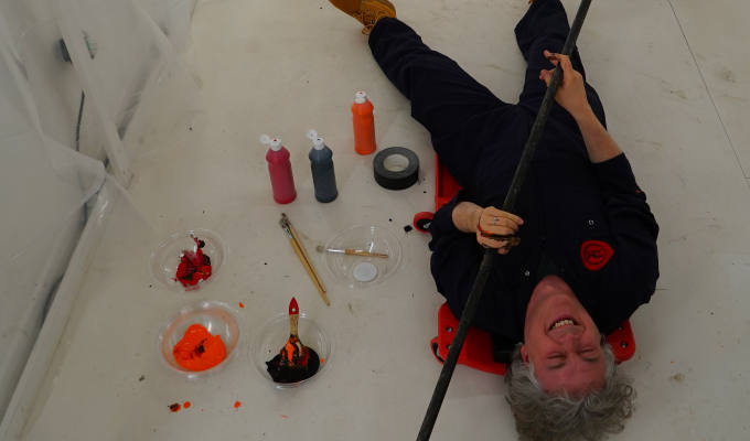 Alan lying on the floor surrounded by paint