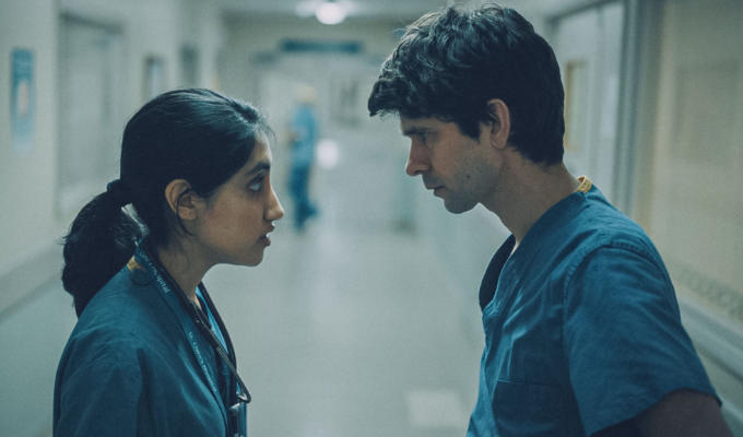 Two doctors looking at each other in a hospital corridor